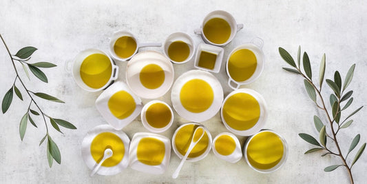 Verschiedene Schalen mit hochwertigem Olivenöl, frisches Brot und Oliven – entdecken Sie die Vielfalt und den einzigartigen Geschmack von kalt gepresstem Olivenöl. Jetzt hochwertiges Olivenöl kaufen und mediterranen Genuss erleben!