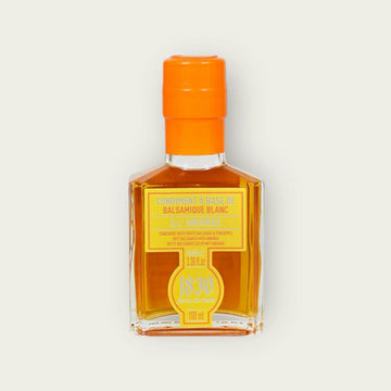 Edle Flasche Ananas Essig Condiment mit leuchtend orangefarbenem Verschluss und stilvollem Etikett. Perfekt für kreative Gerichte und exotische Aromen.