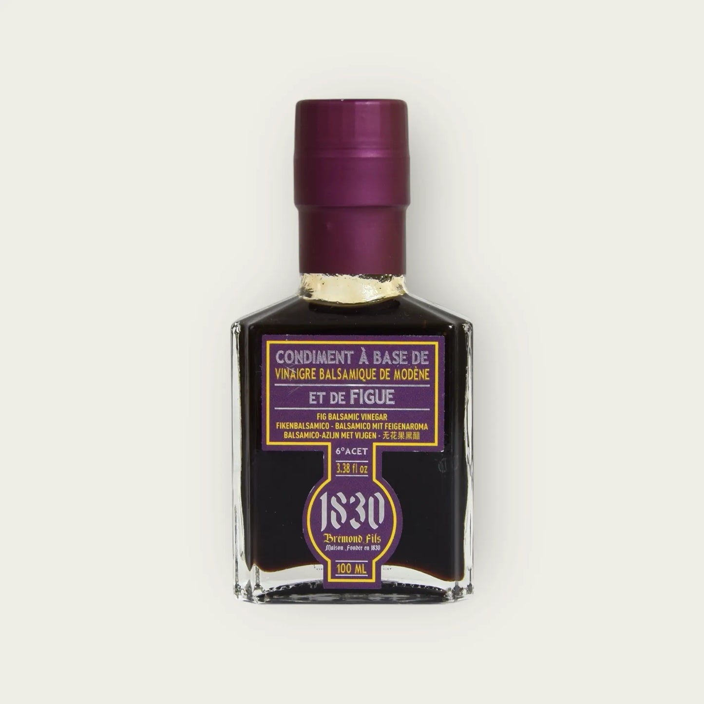 Nahaufnahme der Maison Brémond 1830 Feigen-Balsamico Essigflasche mit lila Etikett und tiefdunklem Inhalt auf hellem Hintergrund.