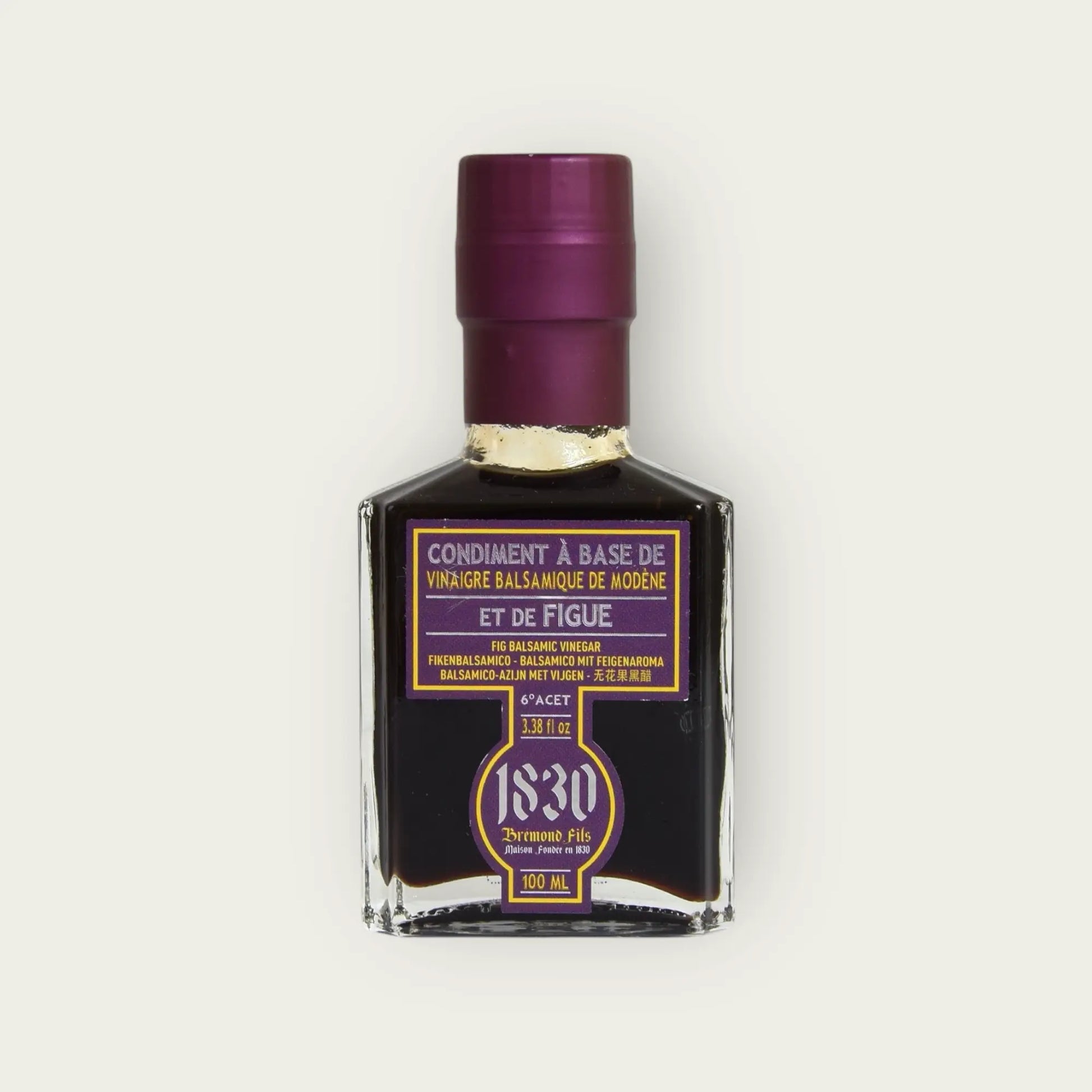 Nahaufnahme der Maison Brémond 1830 Feigen-Balsamico Essigflasche mit lila Etikett und tiefdunklem Inhalt auf hellem Hintergrund.