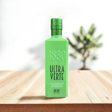 Edle grüne Flasche mit Bio-Olivenöl aus Spanien – Ultra Verte, extra natives Olivenöl aus 100 % Hojiblanca-Oliven, präsentiert auf einem Holztisch mit natürlichem Hintergrund.