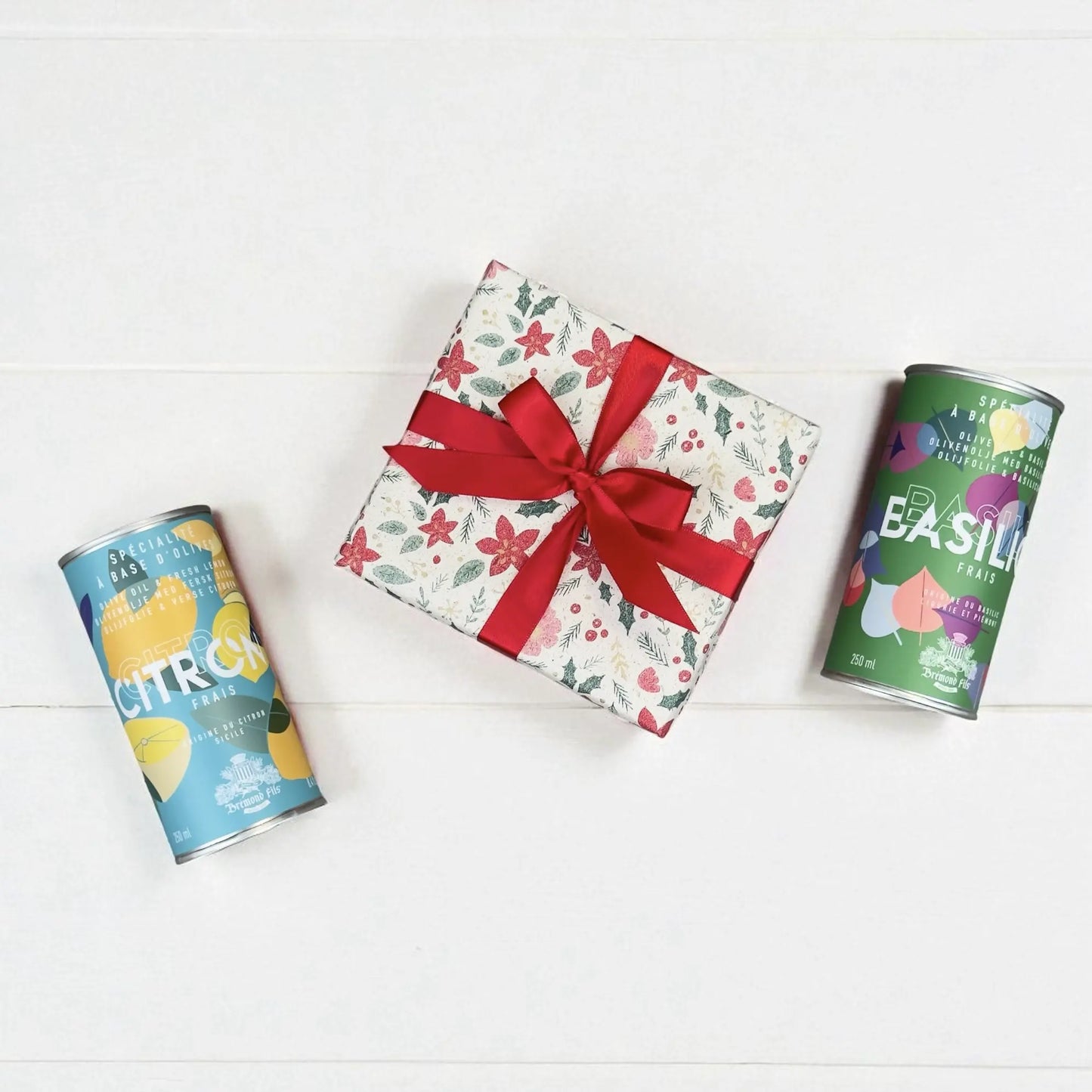 Weihnachts-Geschenkset von Maison Brémond 1830 mit Olivenöl Basilikum und Olivenöl Zitrone in dekorativen Dosen, festlich verpackt mit roter Schleife.