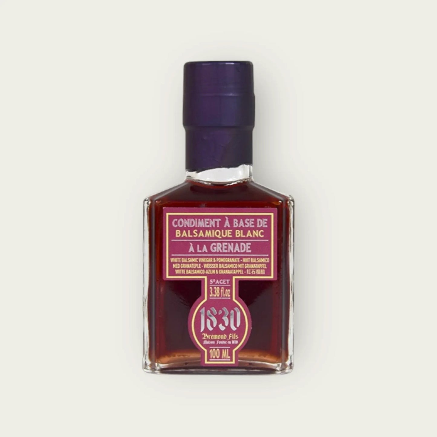 Maison Bremond 1830 Granatapfel-Balsamico-Essig in einer quadratischen Glasflasche mit lila Etikett und Verschluss, 100 ml."