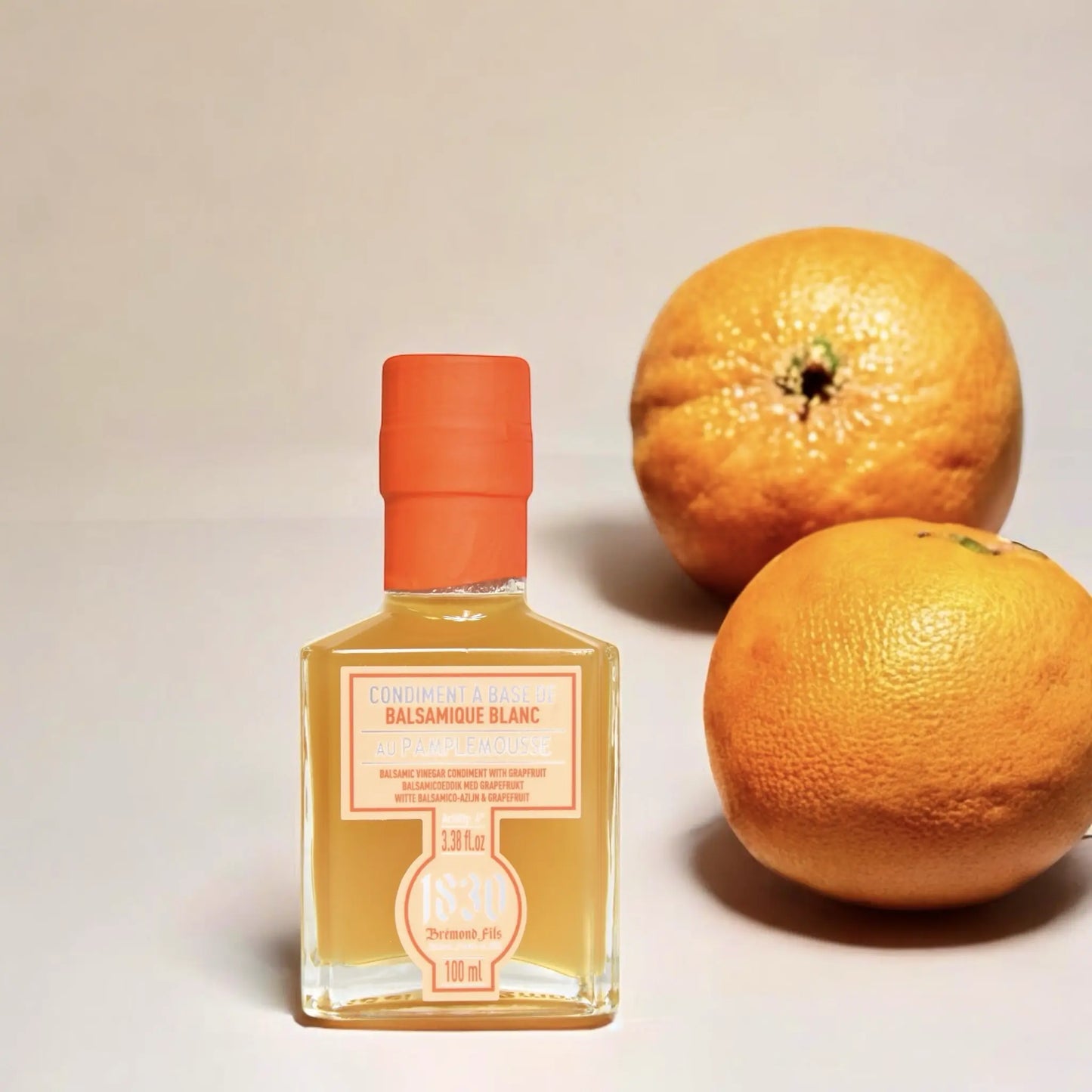 Maison Bremond 1830 Grapefruit-Balsamico-Essig stilvoll inszeniert mit zwei ganzen Grapefruits, die die frische und fruchtige Note des Essigs unterstreichen.