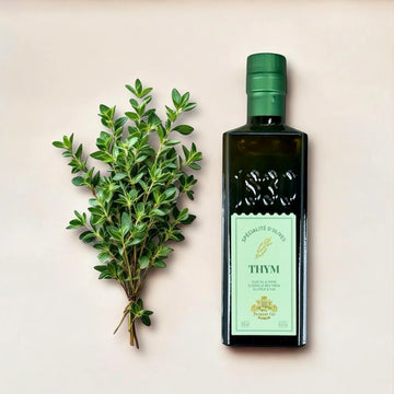 Olivenöl mit Thymian von Maison Brémond 1830 liegend neben frischem Thymian auf beigem Untergrund – französisches Kräuteröl mit mediterraner Note