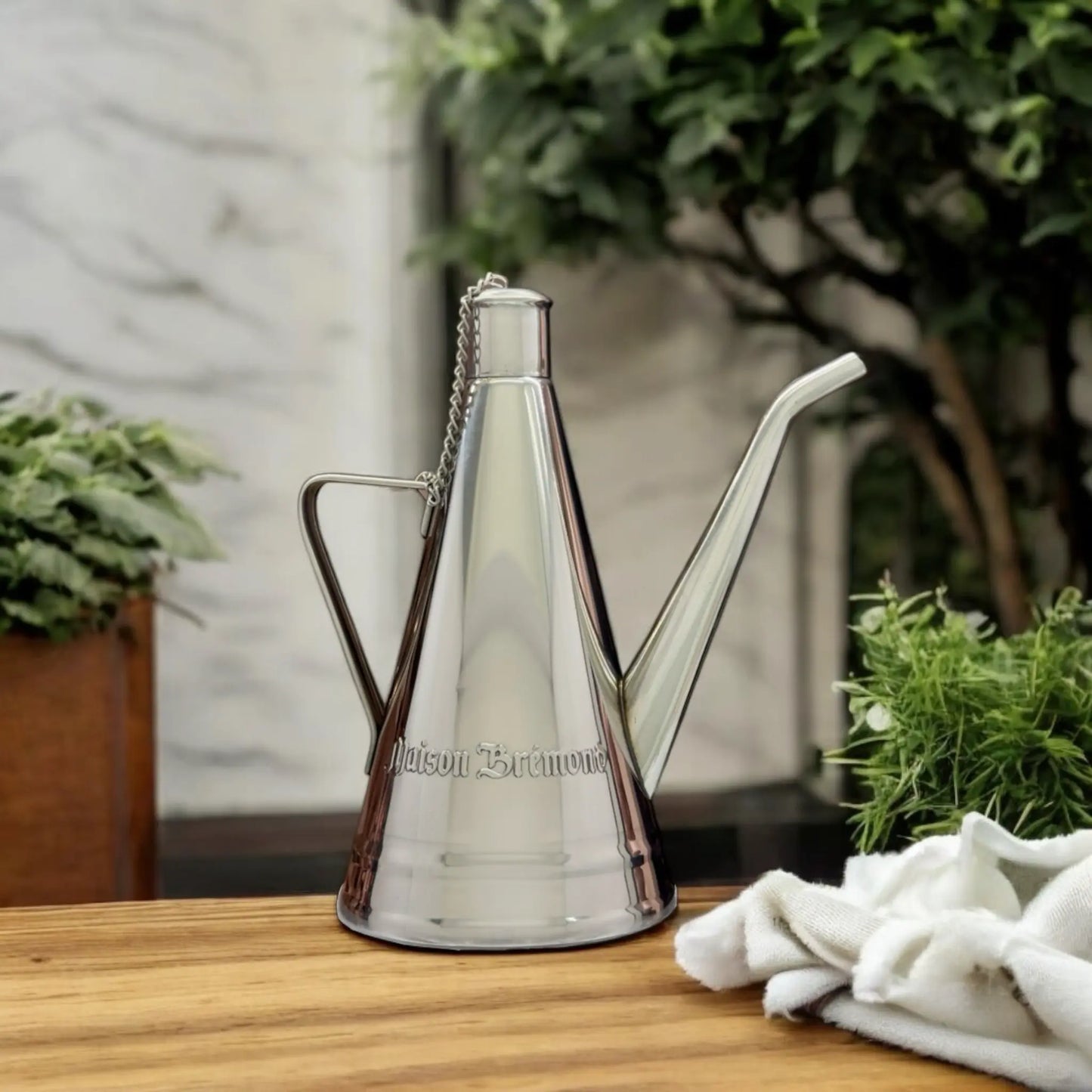 Elegante Edelstahl-Ölkanne für die Küche – Stilvolle Ölkanne aus Inox-Stahl auf einer Holzfläche, perfekt für das präzise Dosieren von Olivenöl.