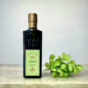 Olivenöl mit Petersilie aus Frankreich in eleganter Flasche – Maison Brémond 1830 Produkt mit frischem Petersilienzweig auf Holzoberfläche