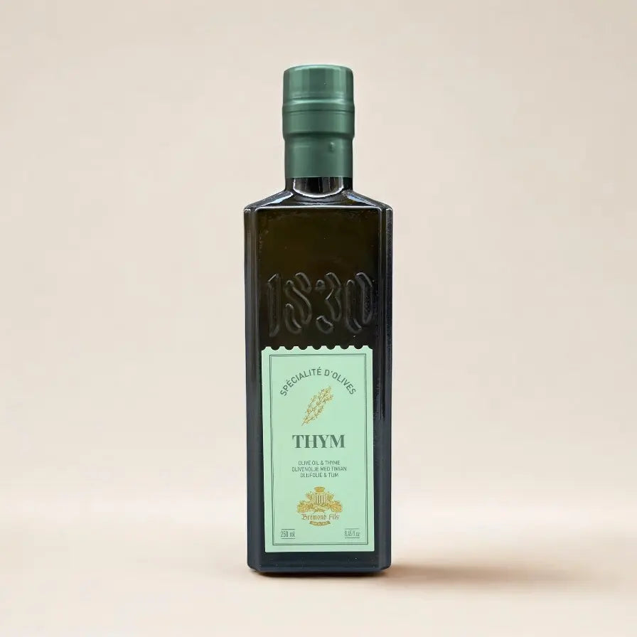 Französisches Thymian-Olivenöl von Maison Brémond 1830 – elegante Flasche mit grüner Etikette vor neutralem Hintergrund