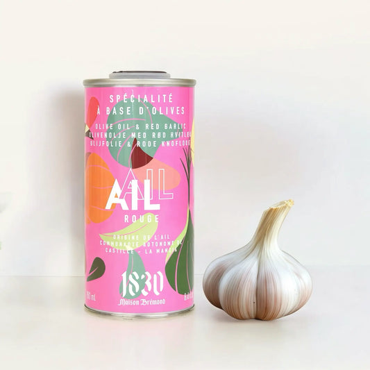 Maison Brémond Knoblauch-Olivenöl 250 ml – Aromatisches Olivenöl mit rotem Knoblauch, präsentiert neben frischen Knoblauchknollen auf hellem Hintergrund.