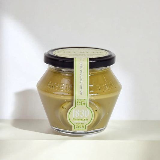 Glas mit Pistaziencreme von Maison Brémond, stilvoll präsentiert mit feiner Prägung und grünem Etikett