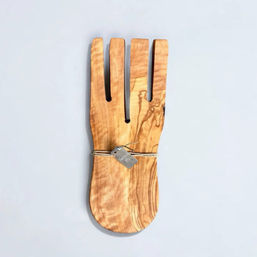 Zusammengebundene Salathände aus Olivenholz mit natürlicher Maserung und geschwungenen Zinken, mit Kordel und Metallschild versehen, auf hellem Hintergrund liegend.