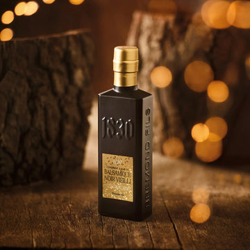 Luxuriöser schwarzer Balsamico-Essig – 20 Jahre gereift in einer eleganten schwarzen Flasche mit goldener Kappe, stilvoll inszeniert mit warmen Lichtakzenten.