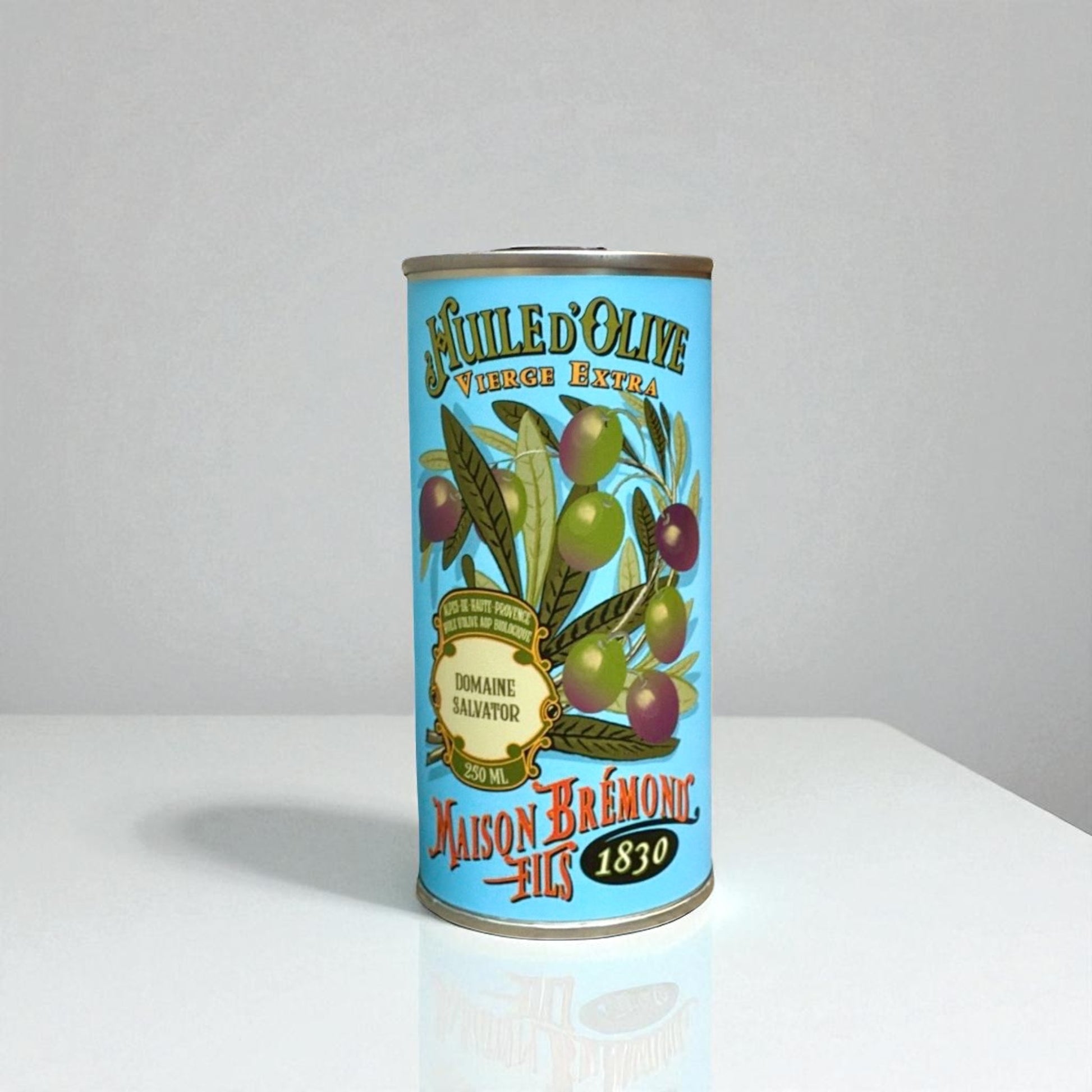 Testsieger-Bio-Olivenöl Domaine Salvator auf einem weißen Tisch. Die dekorative Dose ist mit Olivenzweigen und Olivenmotiven verziert.