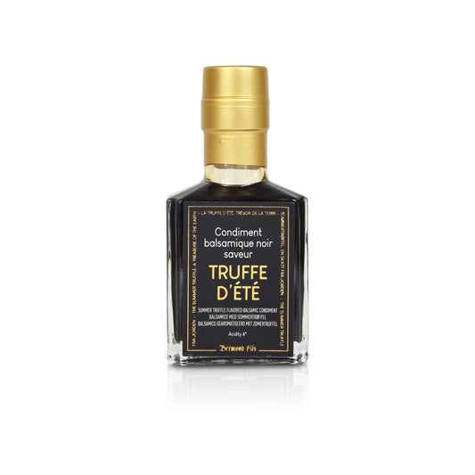 Flasche mit schwarzem Balsamico-Condiment und Sommertrüffel-Aroma. Goldfarbener Verschluss, Etikett mit der Aufschrift "Condiment balsamique noir saveur Truffe d'Été". Hochwertiges Produkt für Gourmet-Gerichte.