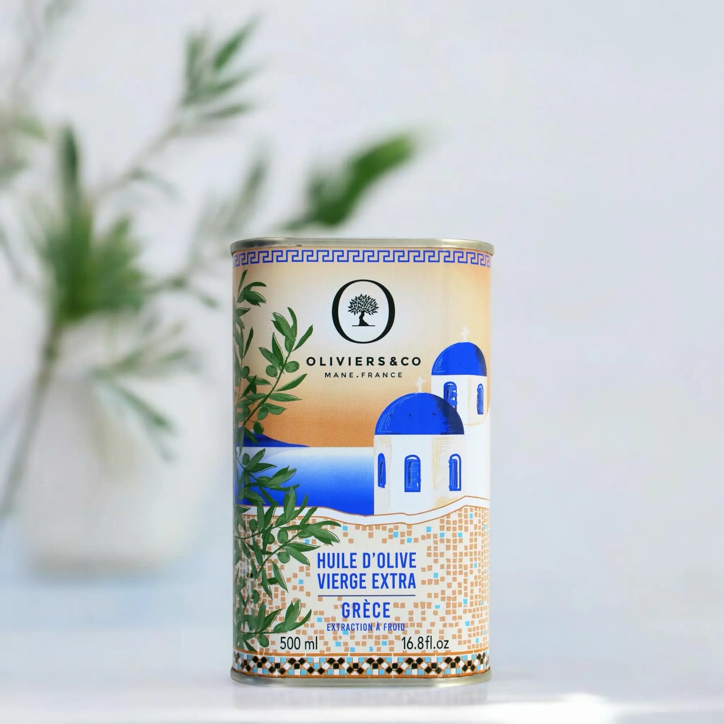 500 ml Dose griechisches Olivenöl von Oliviers & Co, verziert mit einem Bild einer traditionellen blau-weißen Kapelle und einem Olivenzweig. Die Verpackung betont die Herkunft und Qualität des extra nativen Olivenöls. Ideal für Liebhaber von authentischem griechischem Olivenöl.
