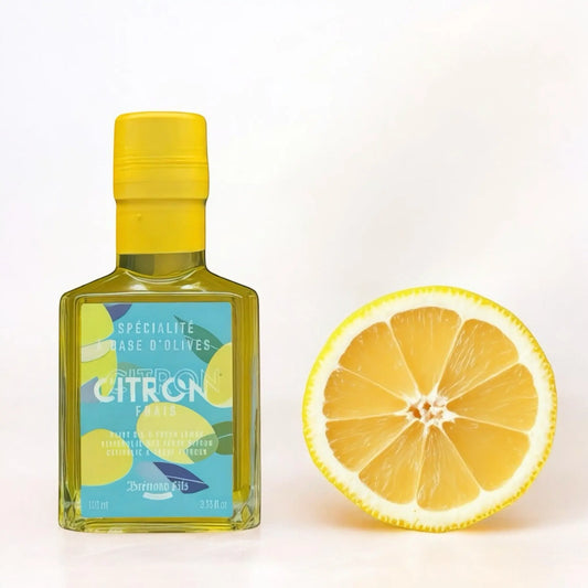 Flasche mit 100 ml Olivenöl mit frischer Zitrone von Maison Brémond, präsentiert auf hellem Hintergrund mit einer aufgeschnittenen Zitrone.