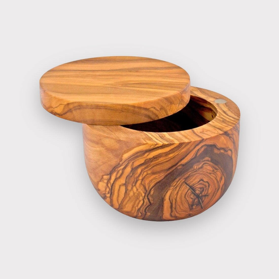 Runde Dose aus Olivenholz mit natürlicher, markanter Maserung und drehbarem Deckel, auf hellem Hintergrund präsentiert.