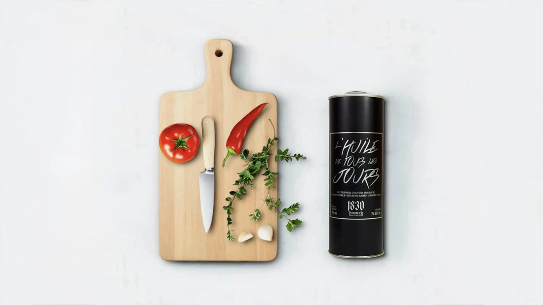 Hochwertiges Olivenöl zum Braten und Kochen im stilvollen schwarzen Kanister, begleitet von frischen Zutaten wie Tomate, Chili, Kräutern und Knoblauch auf einem Holzbrett. Perfekt für die tägliche Küche.