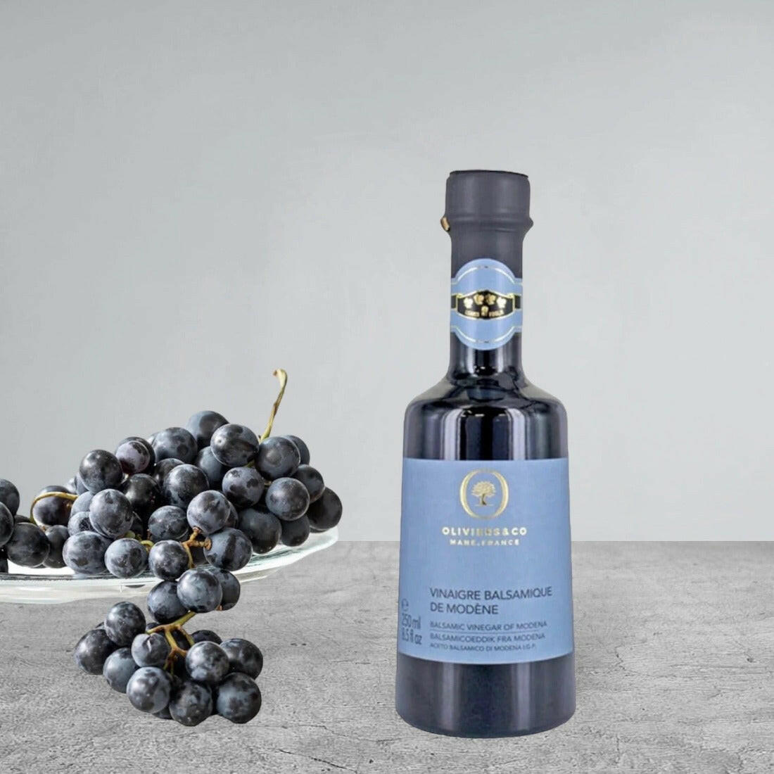 Flasche Balsamico-Essig aus Modena von Oliviers & Co mit traditionellem Etikett. Die Flasche steht auf einem neutralen Hintergrund und präsentiert das Produkt in seiner klassischen Verpackung, bekannt für seinen unverwechselbaren Geschmack und seine Qualität.
