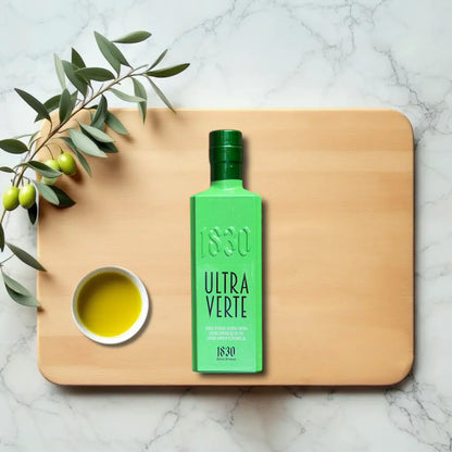 Ultra Verte Bio-Olivenöl aus Spanien – exklusive grüne Flasche mit hochwertigem extra nativem Olivenöl, platziert auf einer Marmorplatte mit Olivenzweig und Schale Olivenöl.