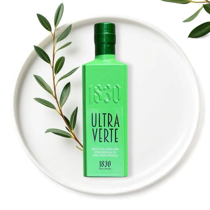 Bio-Olivenöl aus Spanien – Ultra Verte in edler grüner Flasche, stilvoll inszeniert mit Olivenzweigen und hochwertigem Design.