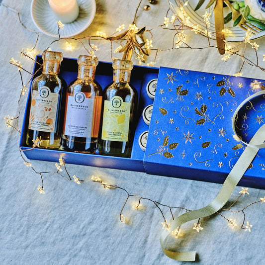 Essig und Oel Geschenkbox ‚Winter Sunshine‘ von Oliviers&Co, festlich arrangiert mit Weihnachtslichtern, Kerzen und goldener Dekoration – das perfekte Weihnachtsgeschenk.