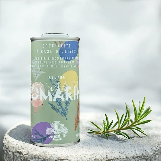 Design-Dose Olivenöl Rosmarin von Maison Brémond 1830, 250 ml, auf einem stein Fläche mit frischem Rosmarinzweig. Extra natives Olivenöl mit aromatischem Rosmarin, ideal für Fleisch, Gemüse und mediterrane Gerichte. Jetzt kaufen.