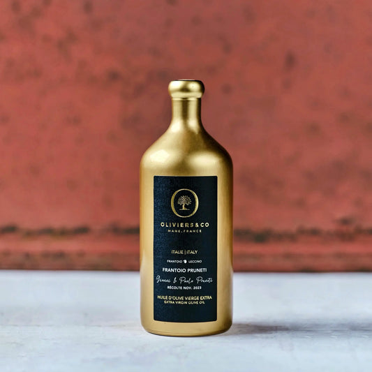 Goldene Flasche Olivenöl aus Italien mit schwarzem Etikett der Marke Oliviers & Co. Das Etikett enthält die Aufschrift "Frantoio Pruneti" und "Extra Virgin Olive Oil" sowie Hinweise auf die Herkunft aus der Toskana, Italien, und das Erntedatum im November 2023. Die elegante Verpackung hebt die Hochwertigkeit des Olivenöls hervor.