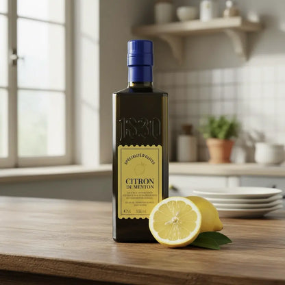 Maison Brémond 1830 Zitronen-Olivenöl Citron de Menton auf hellem Marmor mit halber Zitrone – hochwertiges Olivenöl mit frischem Zitrusaroma.