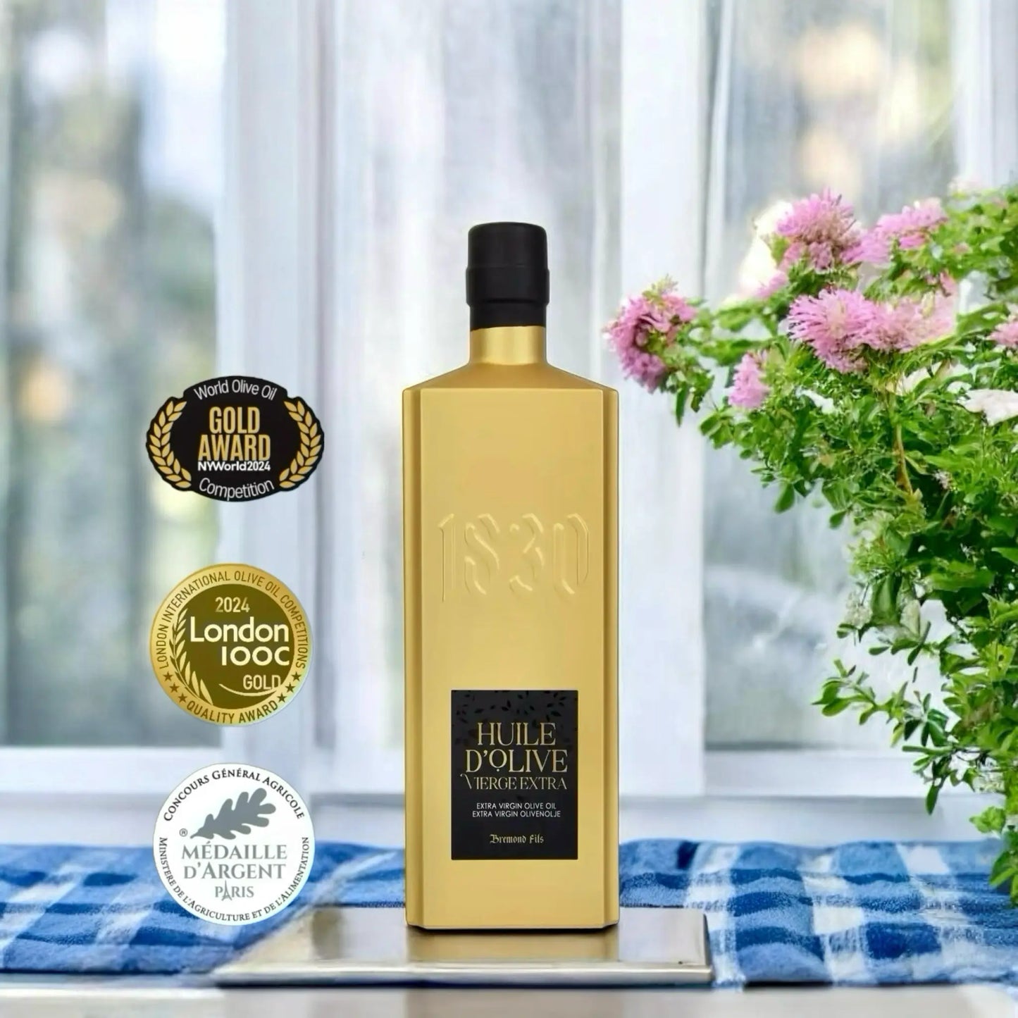 Edle goldene Flasche mit Bio-Testsieger-Olivenöl aus Frankreich – ausgezeichnetes natives Olivenöl extra von 1830 Dreimond Fils, präsentiert mit internationalen Goldmedaillen und Qualitätssiegeln.
