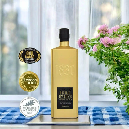 Edle goldene Flasche mit Bio-Testsieger-Olivenöl aus Frankreich – ausgezeichnetes natives Olivenöl extra von 1830 Dreimond Fils, präsentiert mit internationalen Goldmedaillen und Qualitätssiegeln.