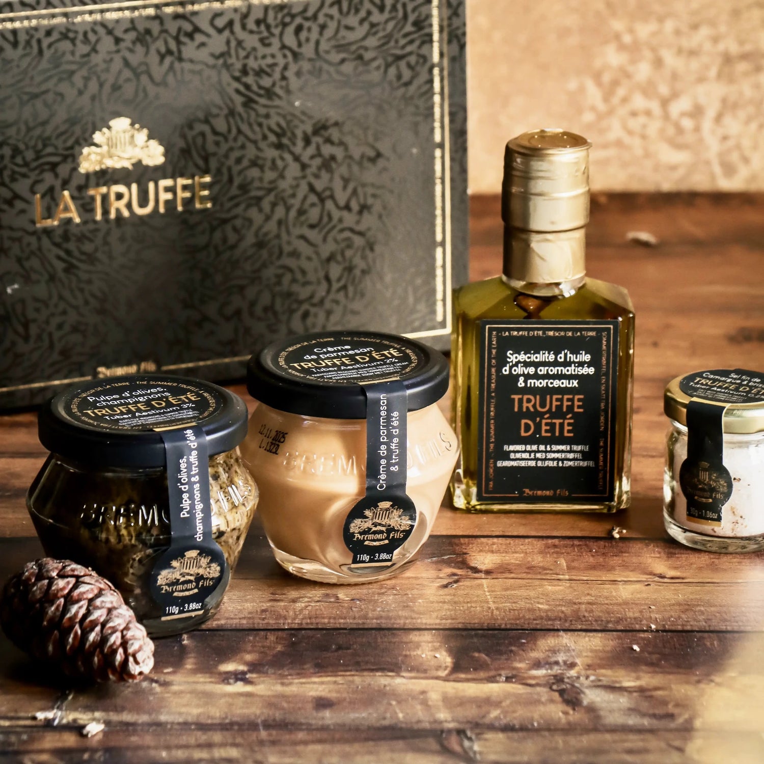 Edle Trüffelprodukte, darunter aromatisiertes Olivenöl, Trüffel-Parmesan-Creme, Olivenpaste mit Trüffel und Trüffelsalz, stilvoll präsentiert in einer luxuriösen Verpackung. Perfekt, um hochwertige Olivenöl Produkte zu kaufen und besondere Aromen zu genießen.